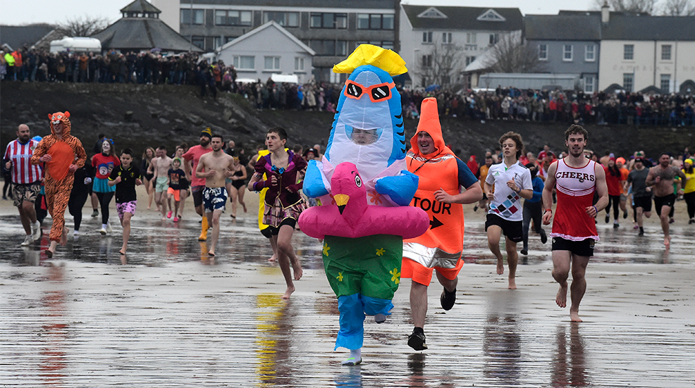 Swimmers run to the beach to take part in the New Year's Day Swim on January 1, 2025 in Saundersfoot, Wales. People use the opportunity to swim in fancy dress and raise money for charities